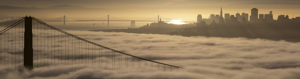 sun rising over San Francisco skyline, fog under the Golden Gate Bridge