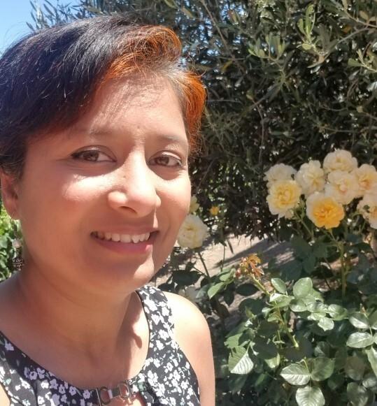 Anya smiling next to flowers