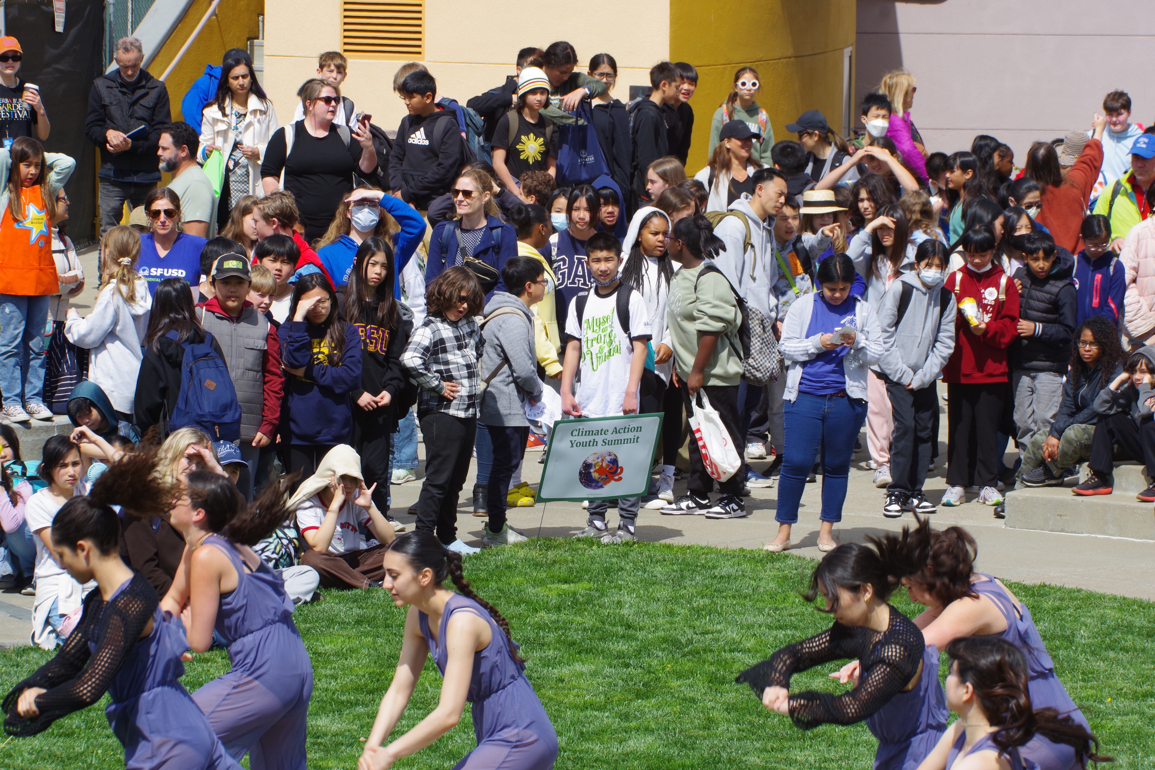 A large group of students, teachers, and attendees gathered outdoors for the Climate Action Youth Summit.