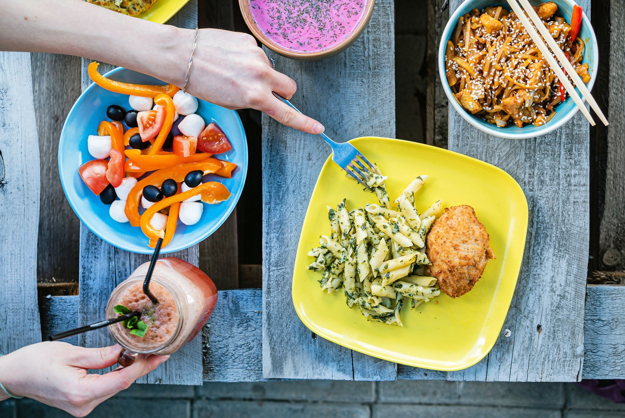 A table with a few multi-colored plates of food