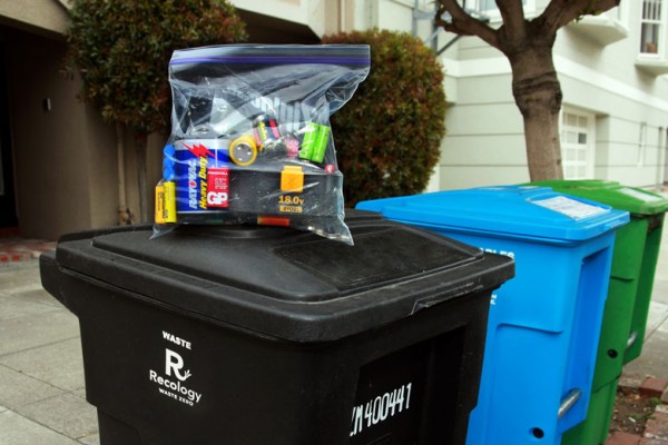 Batteries in a clear plastic bag on top of black bin