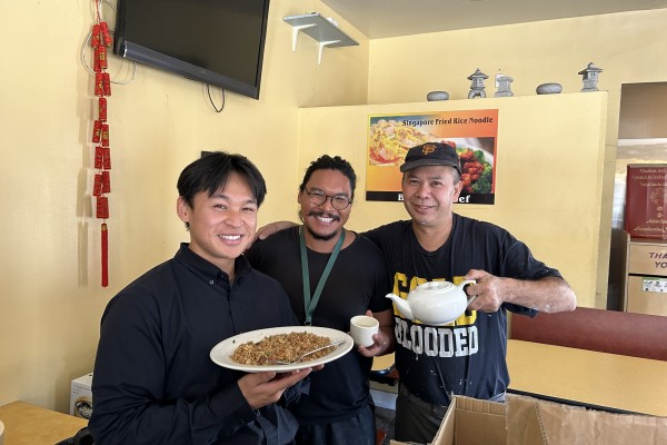 Three people are smiling for a picture. Two of the three are Department staff. The third, on the far right, is a SF restaurant owner holding a reusable ceramic teacup