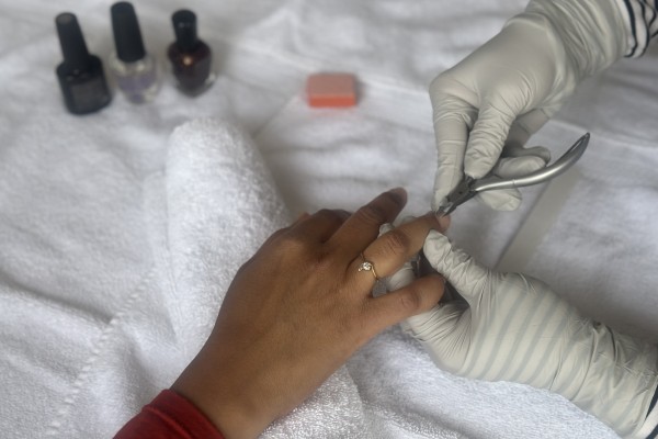 Nail salon technician works with a customer