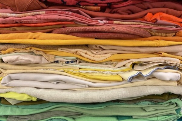 Donated textiles arranged by color like a rainbow
