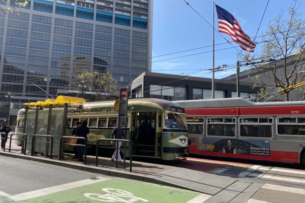 Two San Francisco Muni busses at a stop light on Market street