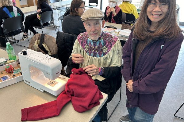 Sewing machine and seamstress at a table