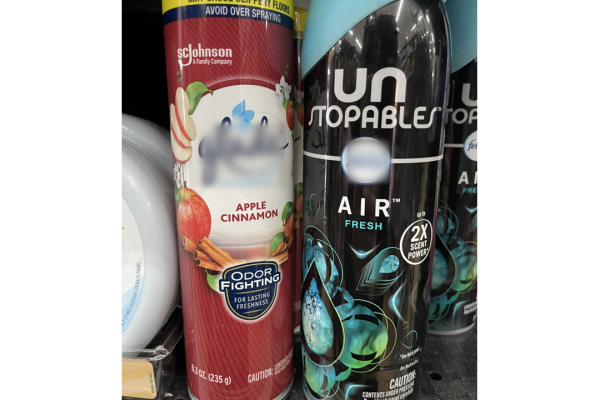 The image shows two air freshener spray cans on a shelf. The can on the left is from SC Johnson and is labeled "Apple Cinnamon," advertised as an odor-fighting spray for lasting freshness. The can on the right is a Febreze Unstopables AIR Fresh spray, marketed with "2X Scent Power." The Unstopables can has a black and blue design with water droplet graphics, indicating a fresh and powerful scent. Both products are positioned side by side, suggesting a variety of options for keeping indoor spaces smelling pl