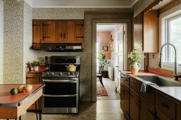 the interior of a kitchen with a sink to the right and a stove in the center