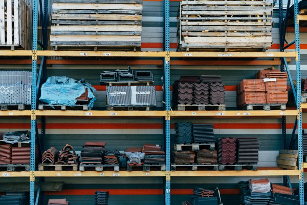 Materials salvaged from demolition site are stacked orderly on metal shelves