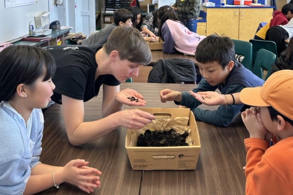 An environmental educator teaching young students about climate action through a hands-on activity.