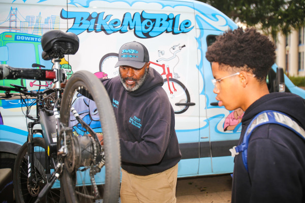 Bicycle repair technician showing a young person how to repair their bike