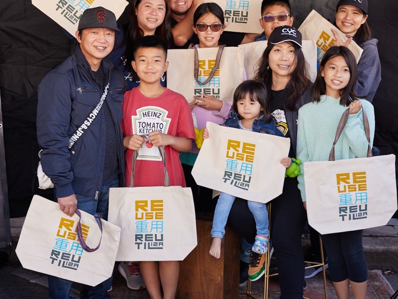 A group of nine people all holding SFE reusable bags