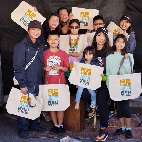 A group of nine people all holding SFE reusable bags