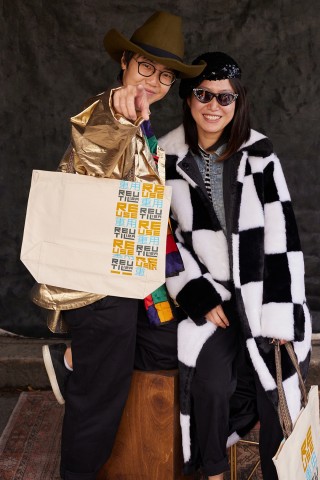 Two individuals pose with their reusable water bottle and shopping bag