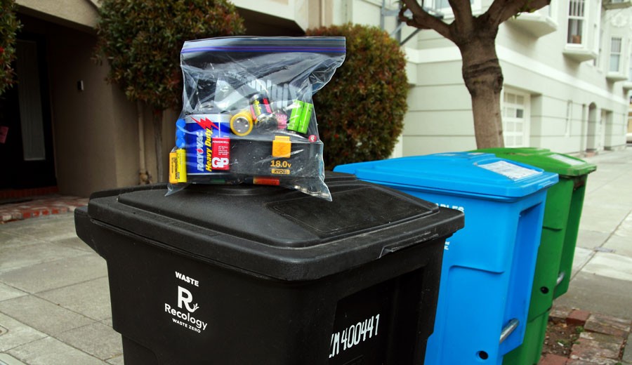 Batteries in a clear plastic bag on top of black bin
