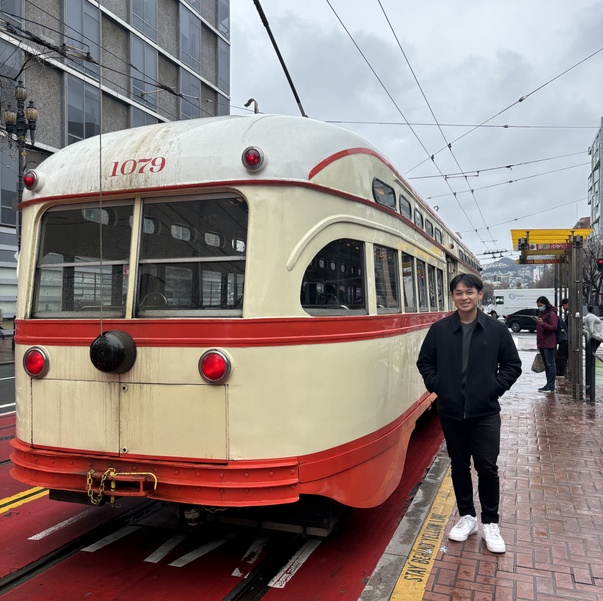 William Zhen smiling next to Muni bus