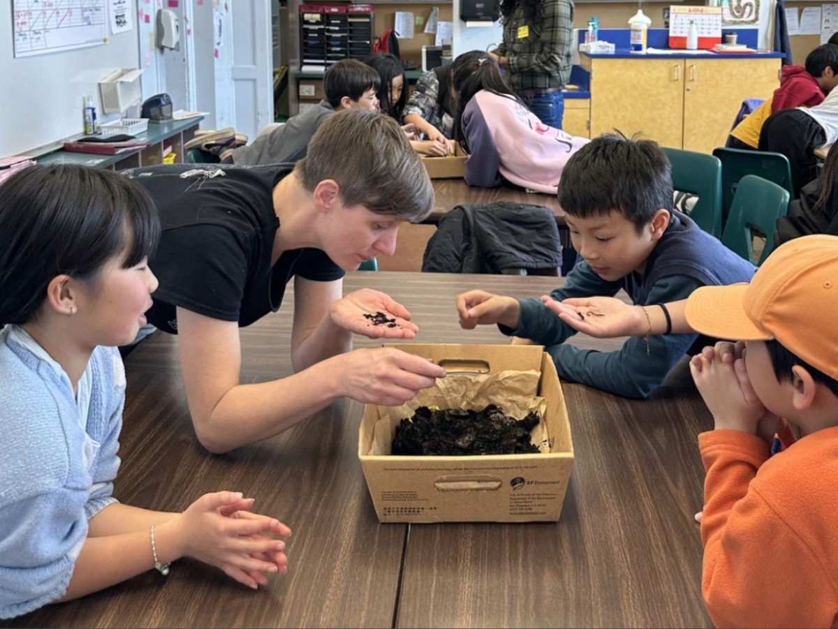 An environmental educator teaching young students about climate action through a hands-on activity.