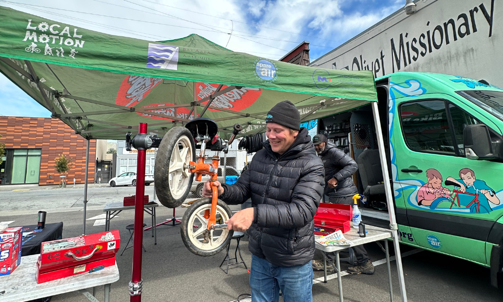 A bike technician works on a small kids bike