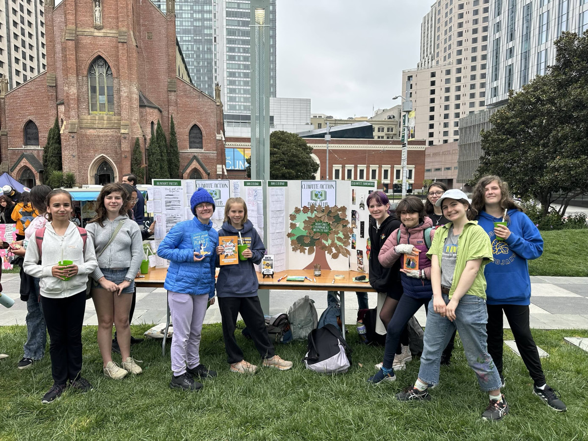 Young students in front of a table at the SF Climate Action Youth Summit event on Earth Day 
