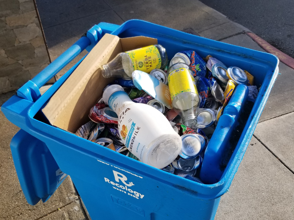 full blue bin with plastic and paper recycling