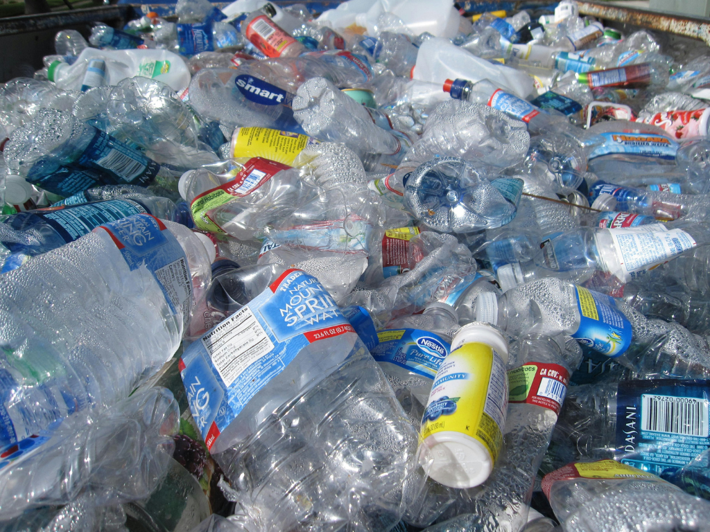 an assortment of plastic waste, mostly clear, squeezable water bottles
