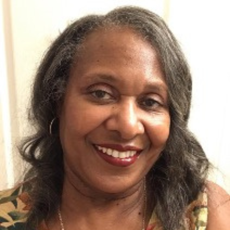A woman with dark hair smiles at the camera