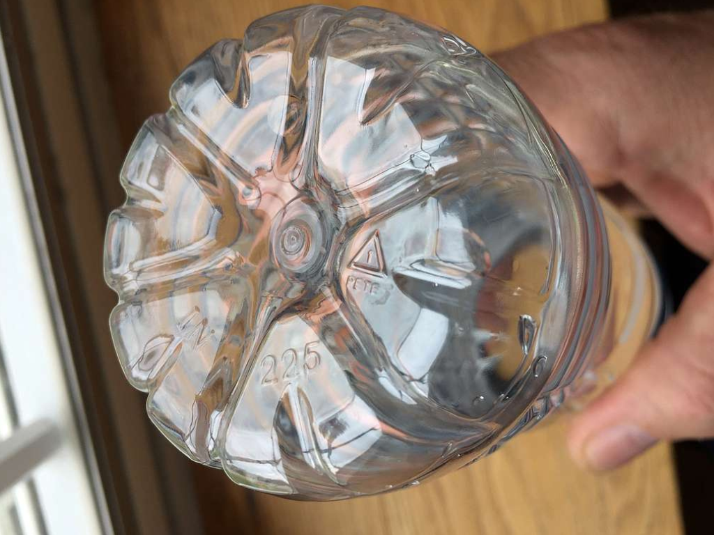 A close-up shot of the bottom of a plastic water bottle