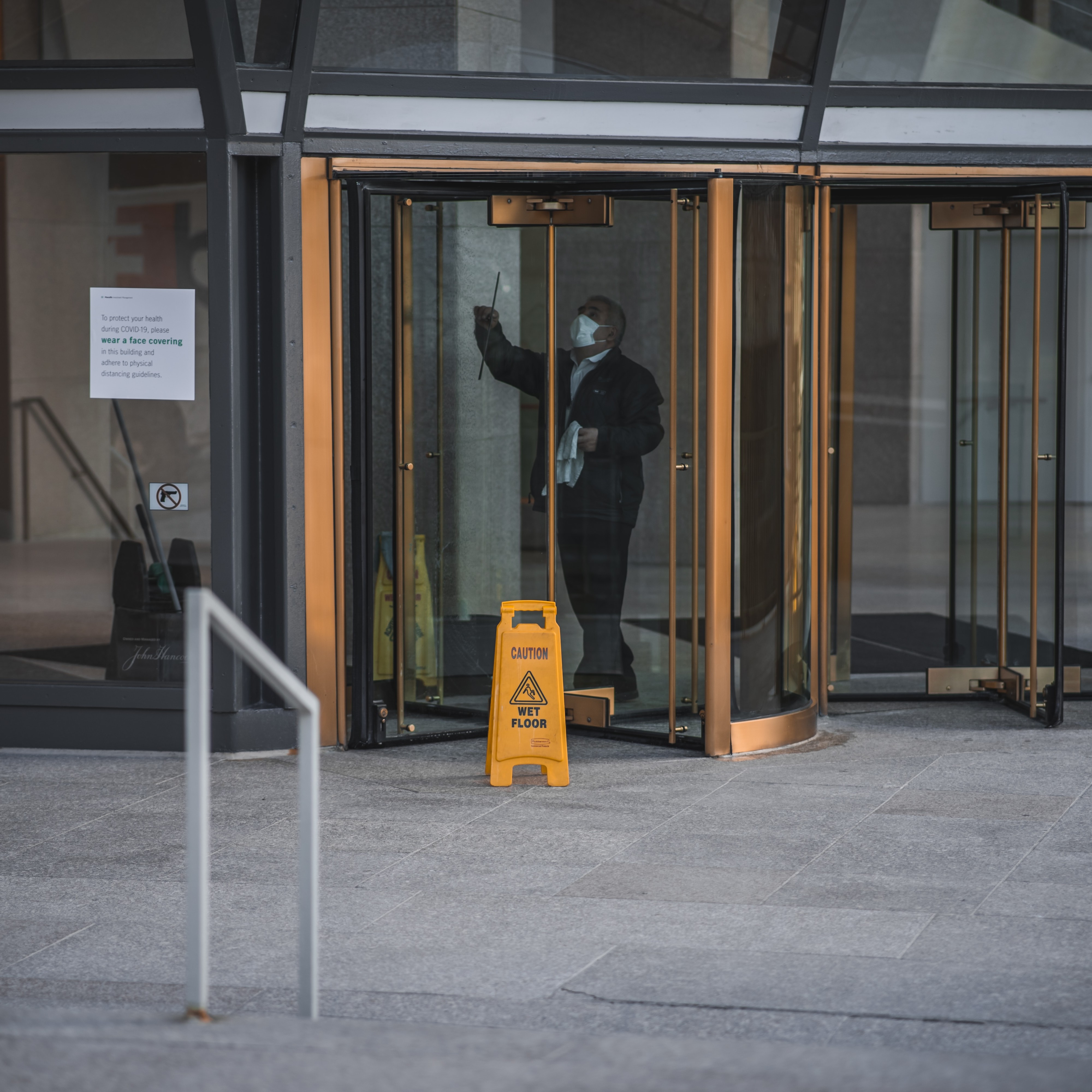 Custodial staff cleaning glass in a commercial office building