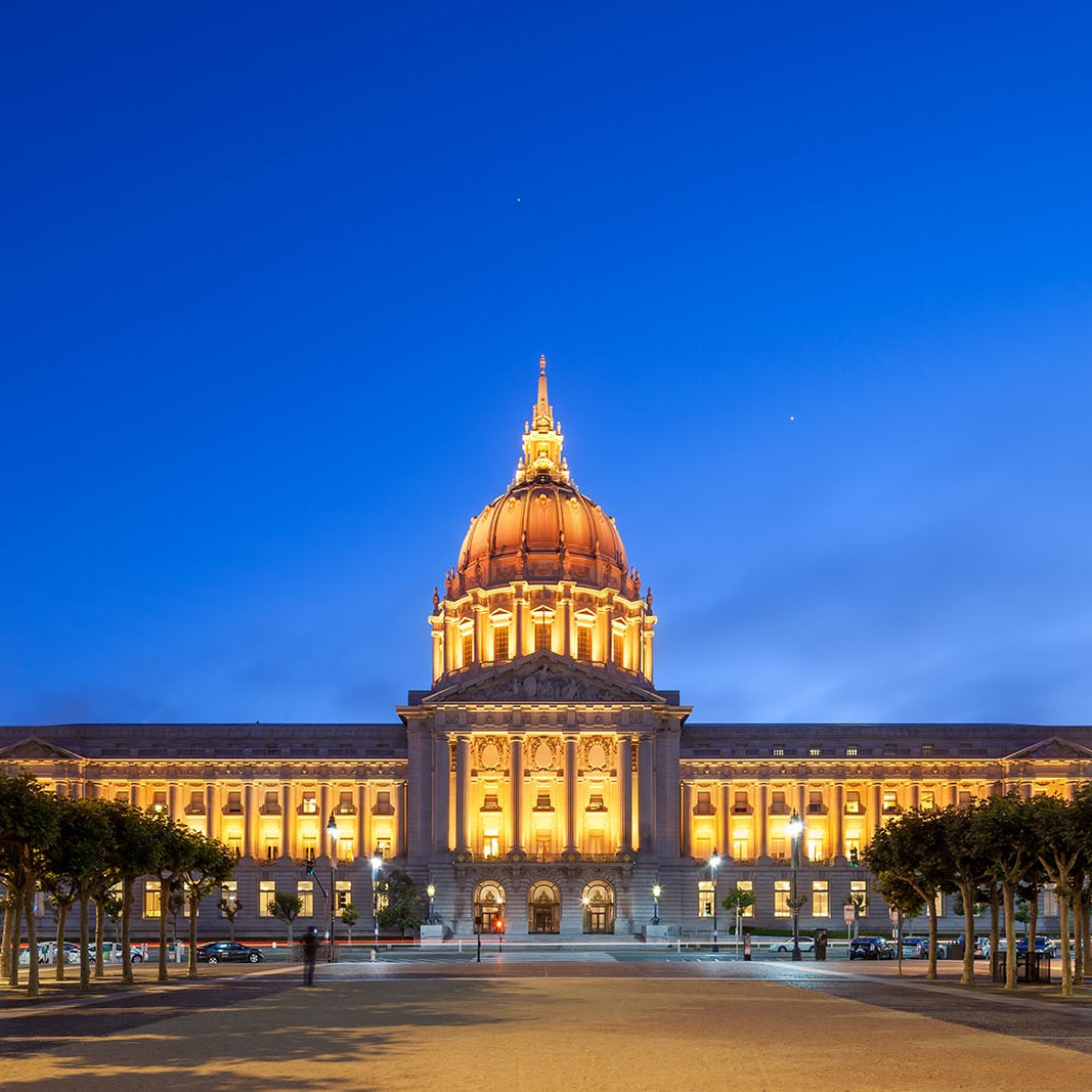 San Francisco City Hall building with gold lights at dusk