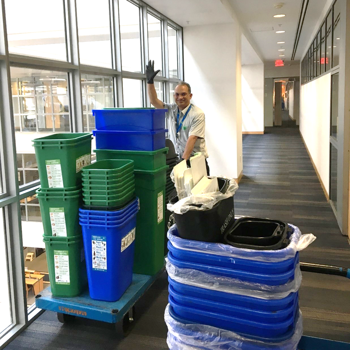 Zero Waste coordinator in a commercial building distributing green and blue bins