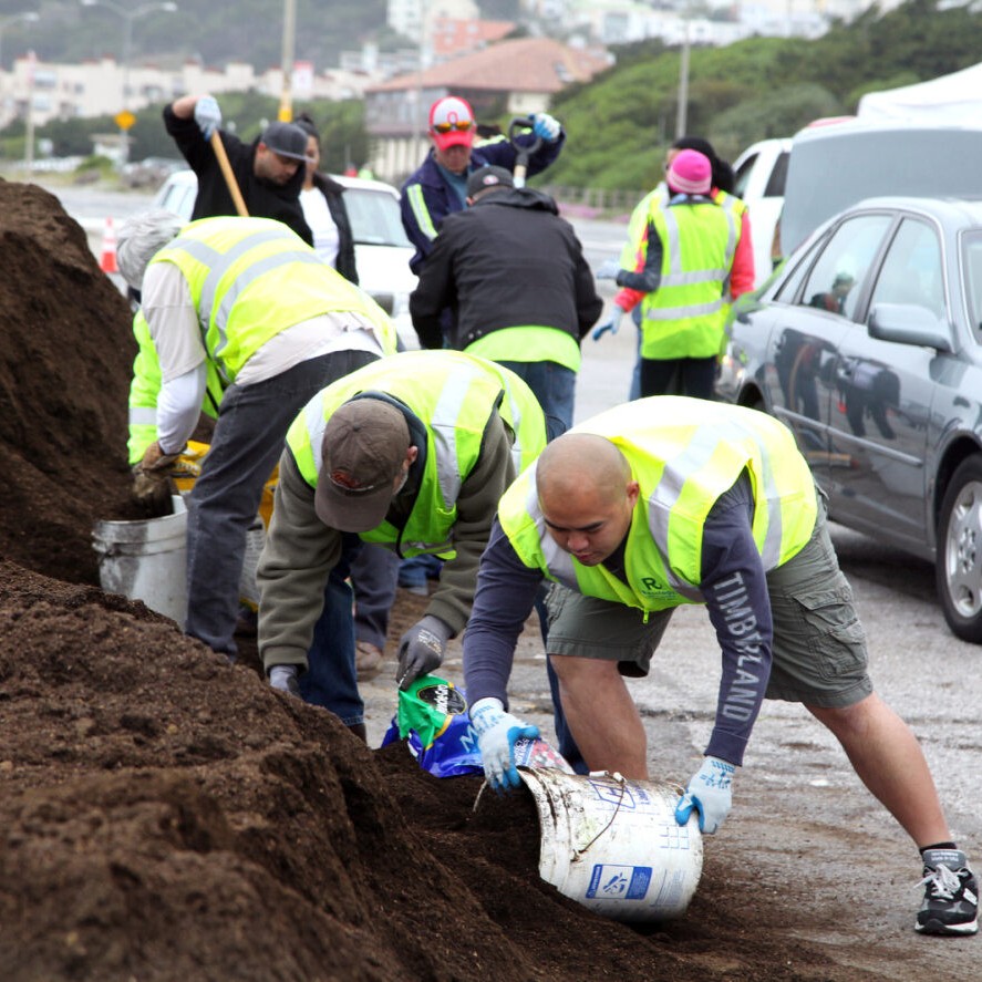 three people with buckets gathering compost soil