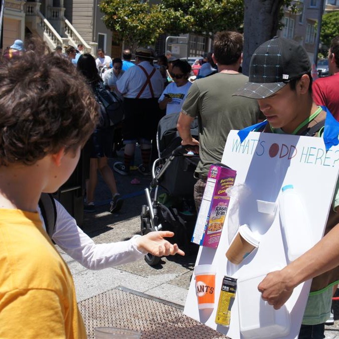 Kids play a game to learn about recycling at an outdoor community festival.