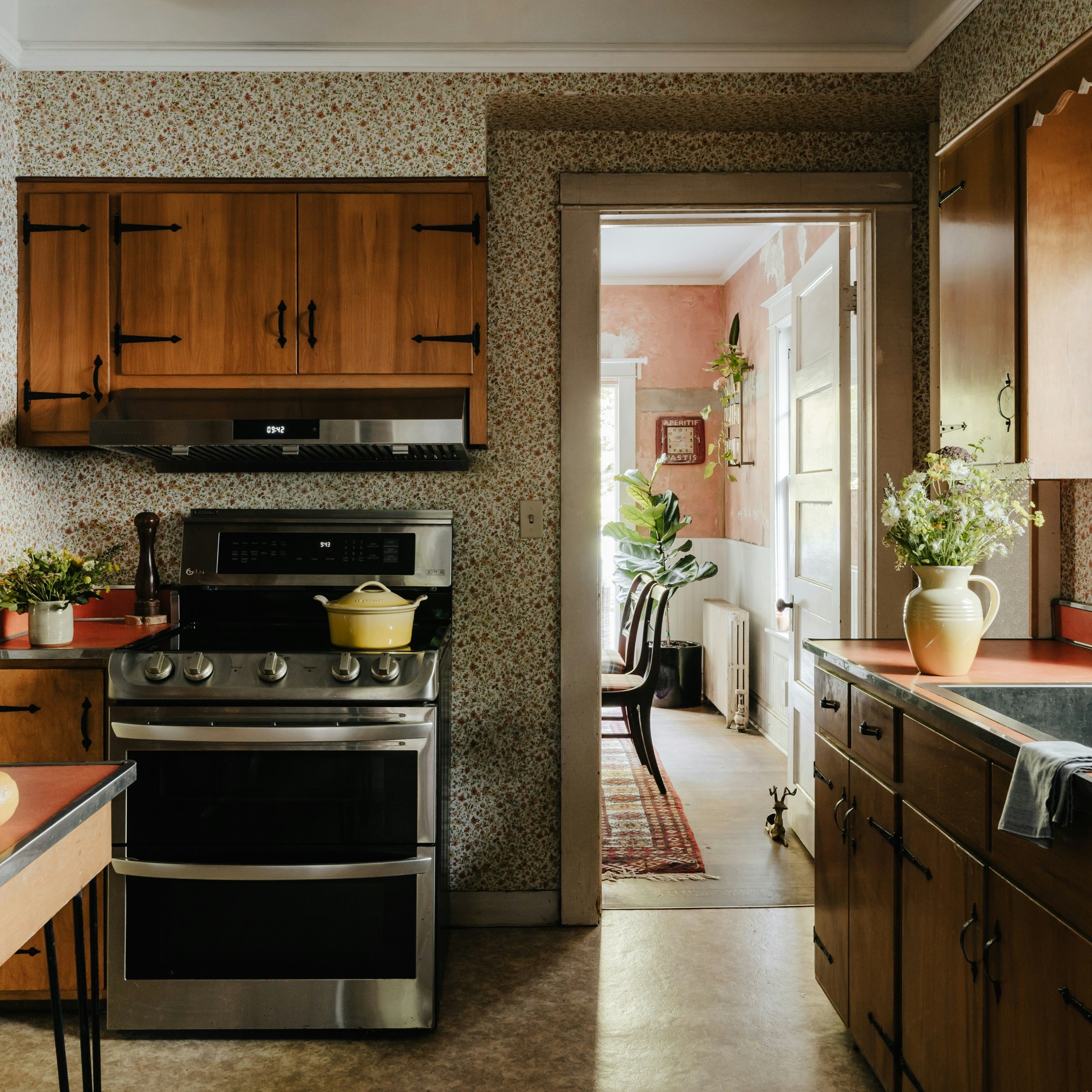 the interior of a kitchen with a sink to the right and a stove in the center