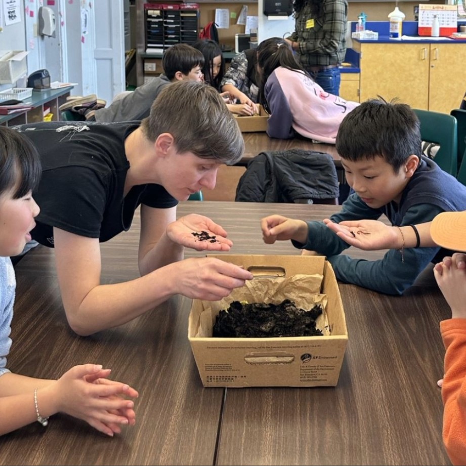 An environmental educator teaching young students about climate action through a hands-on activity.