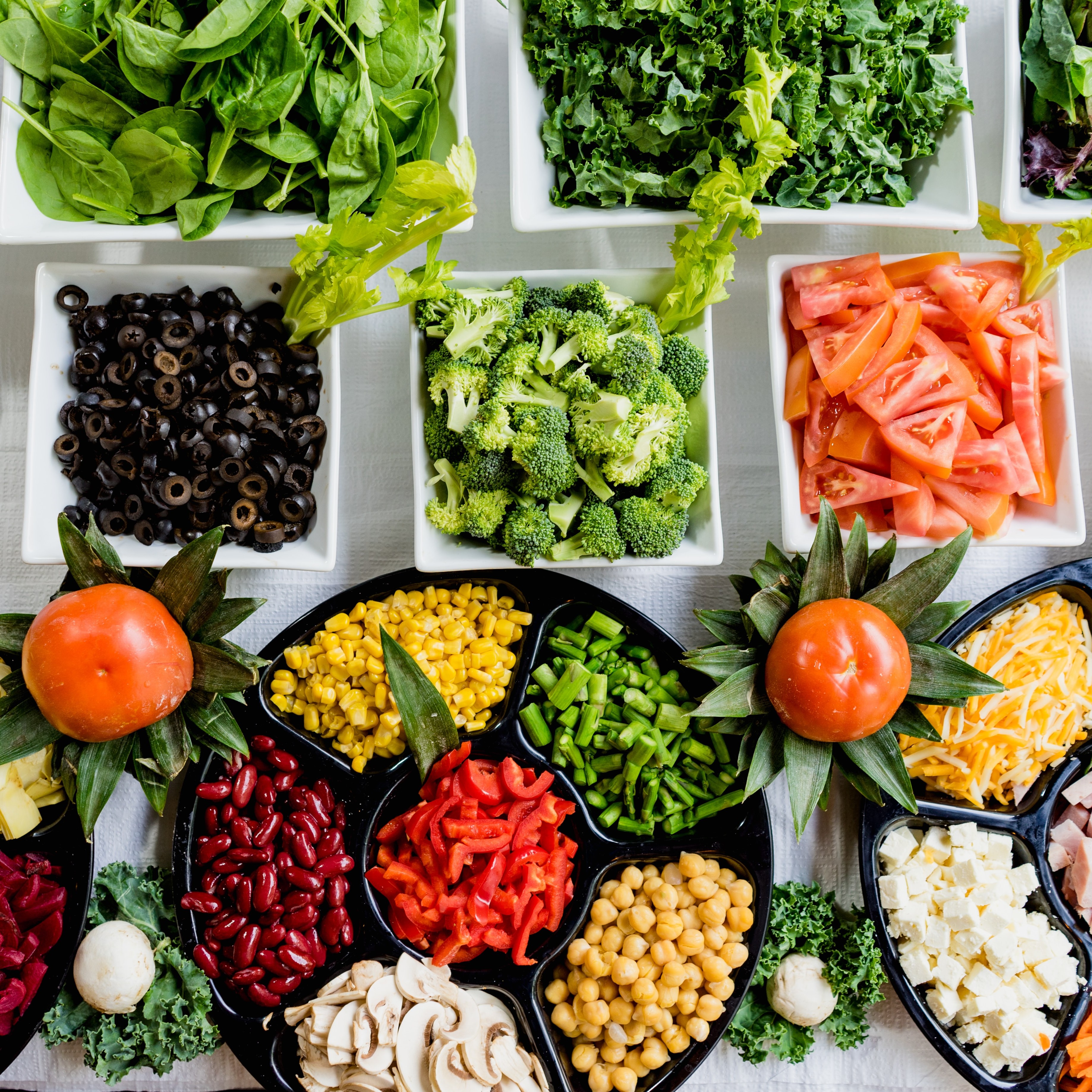 Rows of food mostly vegetables all in separate bowls on a table