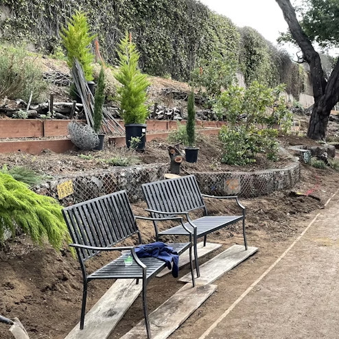 Community garden with two black iron benches