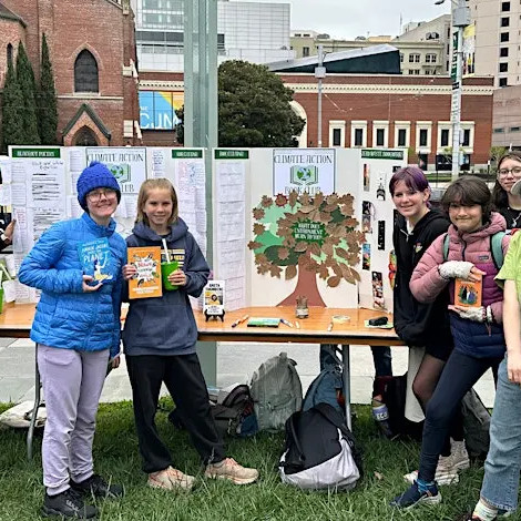 High school students gather around a table to present their climate-related work