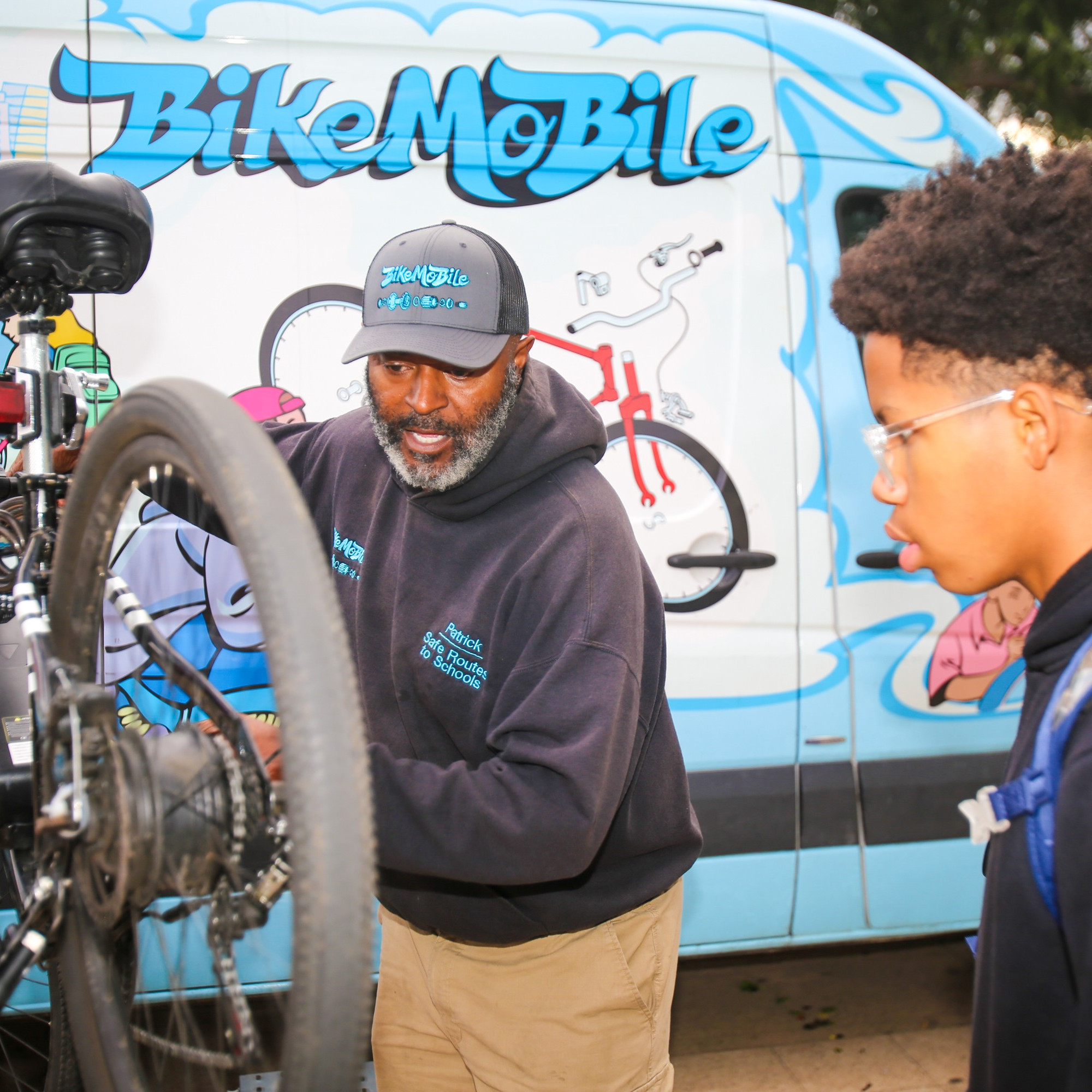 Bicycle repair technician showing a young person how to repair their bike
