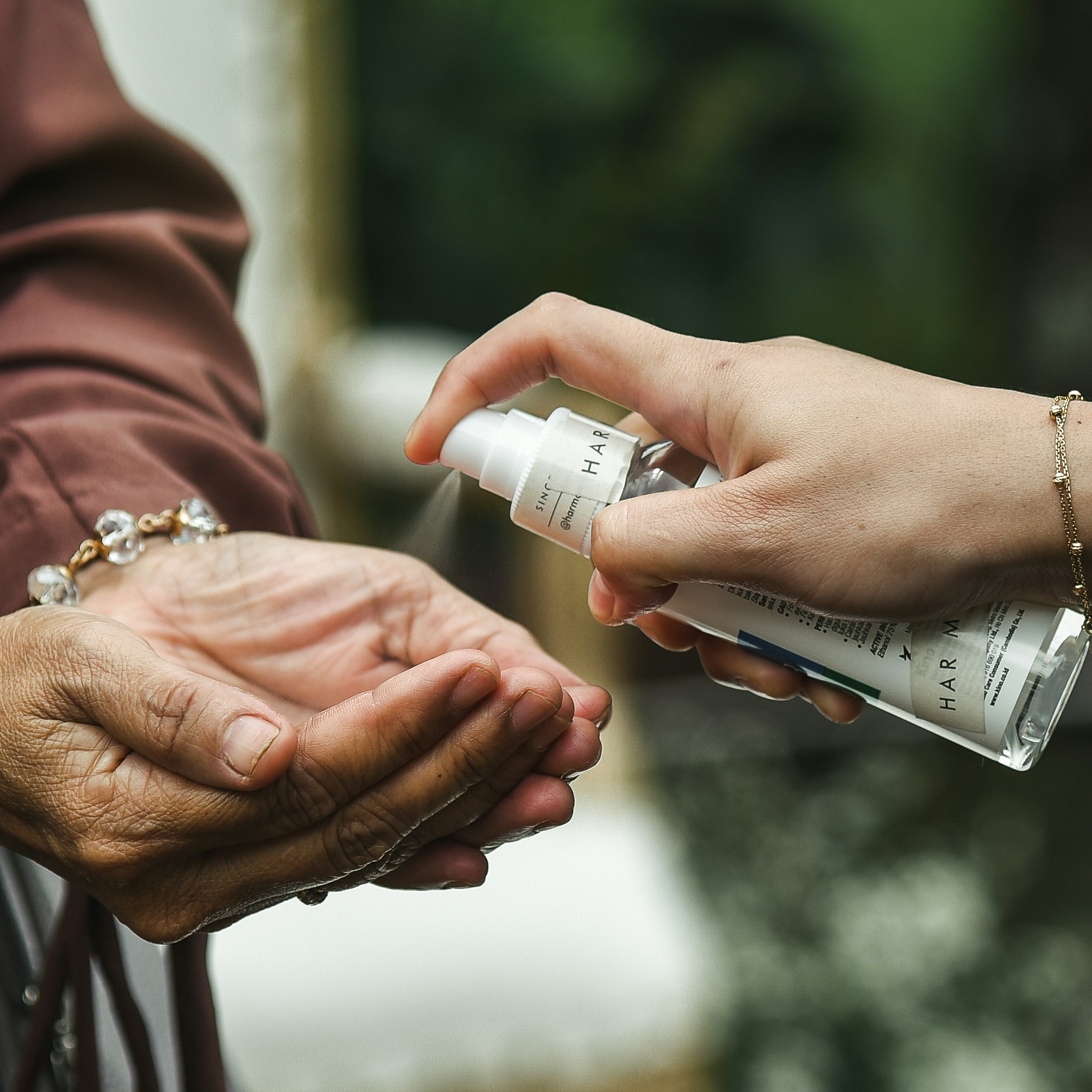 open palms  and a spray bottle with hand sanitizer 